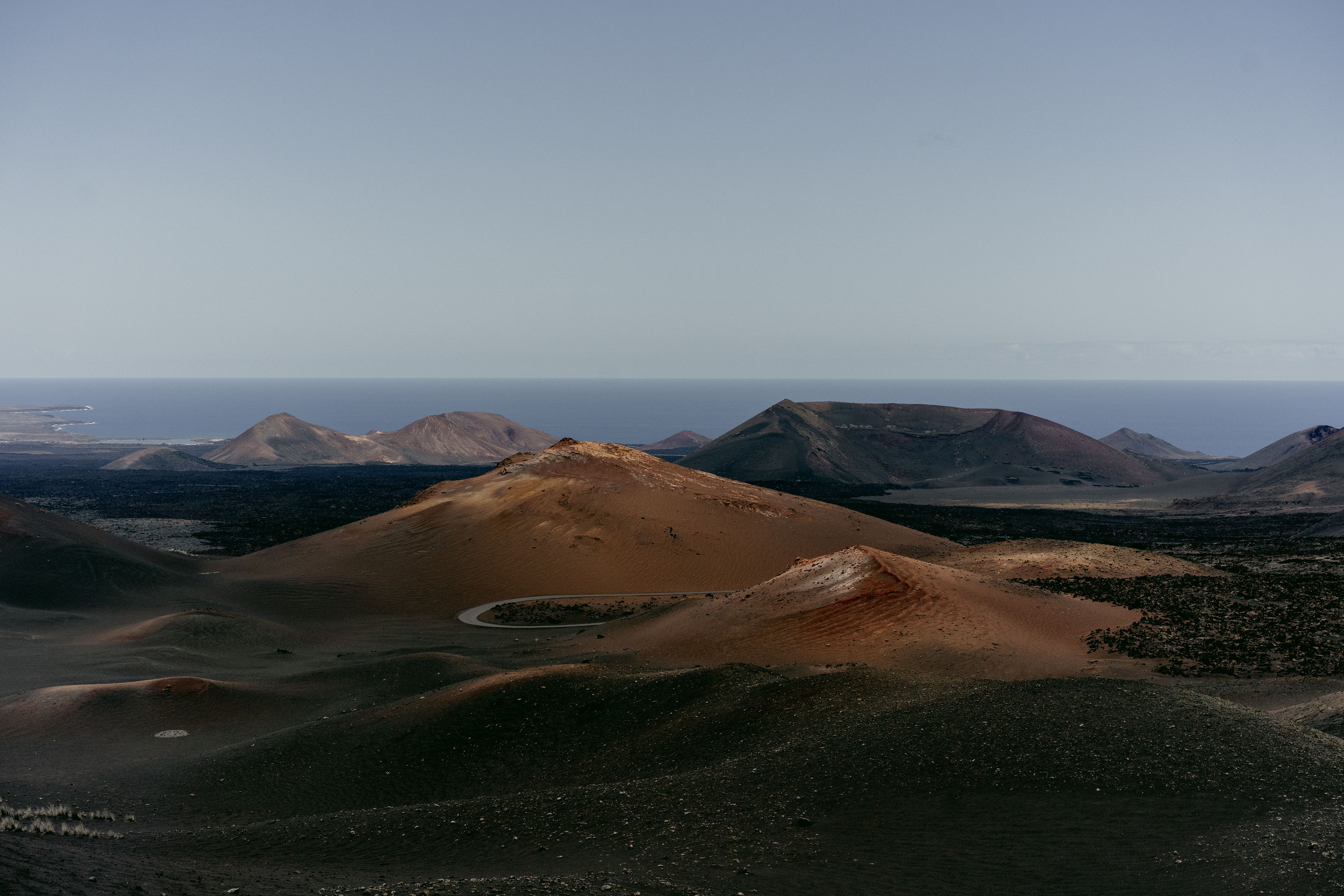 A breathtaking view of a volcanic landscape with distant ocean on a clear day capturing nature's beauty.
