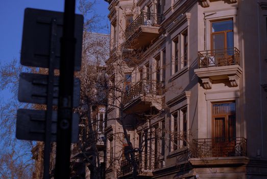 Charming architectural details of a city facade with balconies during sunset, highlighting urban elegance.