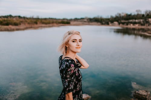 Фотография женщины, стоящей у озера