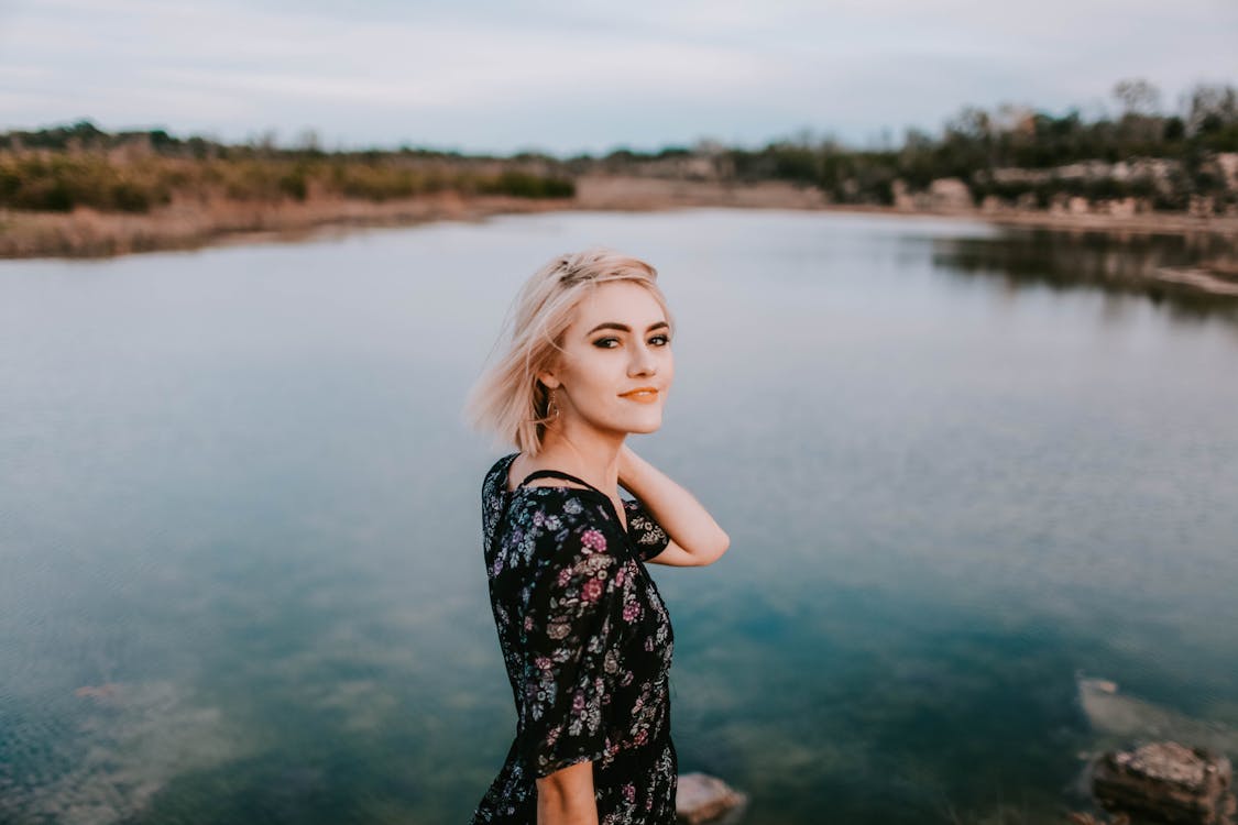 Photo of Woman Standing Beside Lake