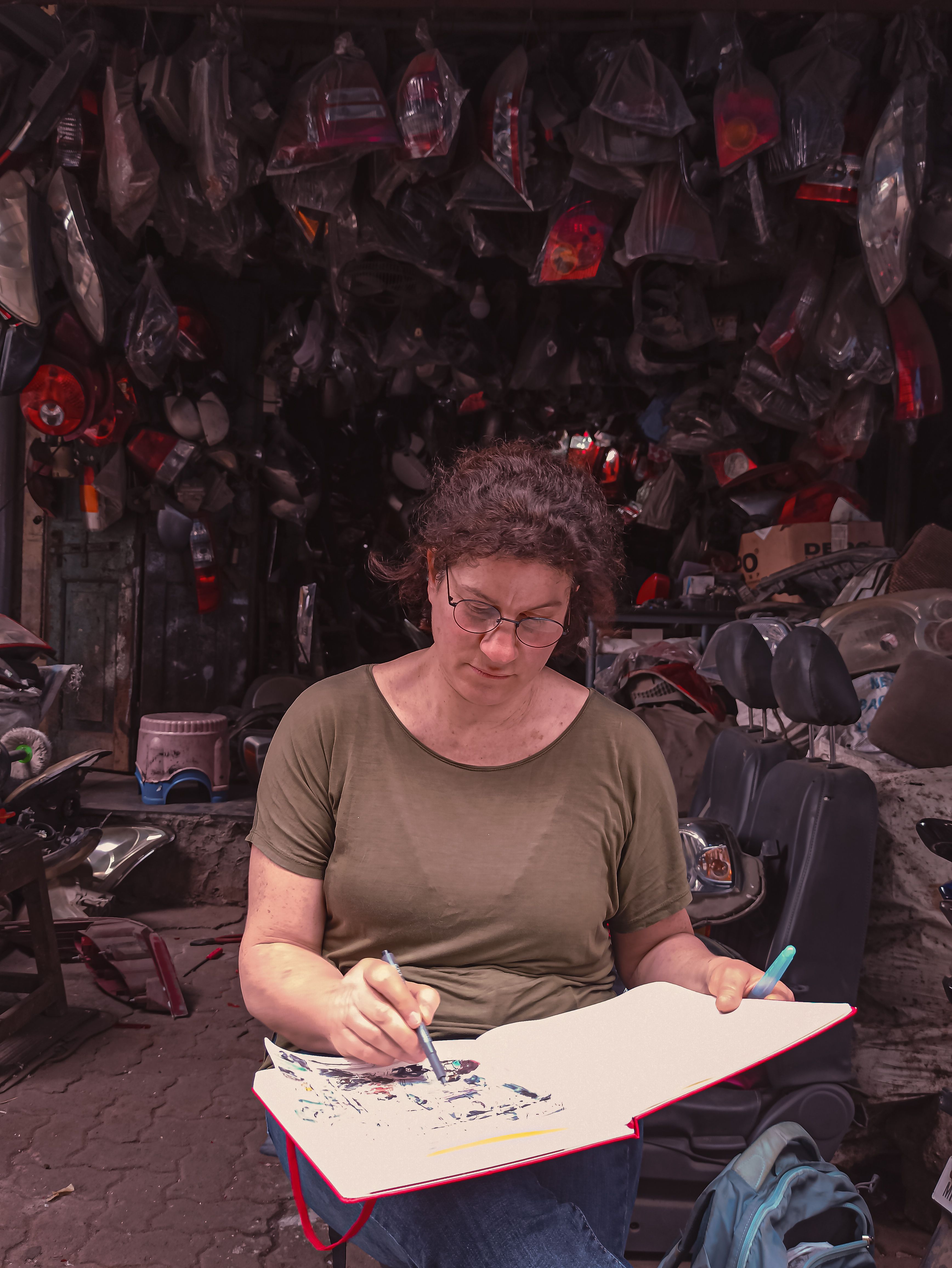 An artist sketching inside a motorcycle shop in Mumbai, capturing urban life with creativity.