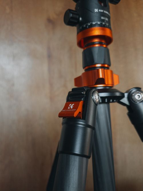 Free Detailed view of a professional tripod with orange accents, ideal for photography enthusiasts. Stock Photo