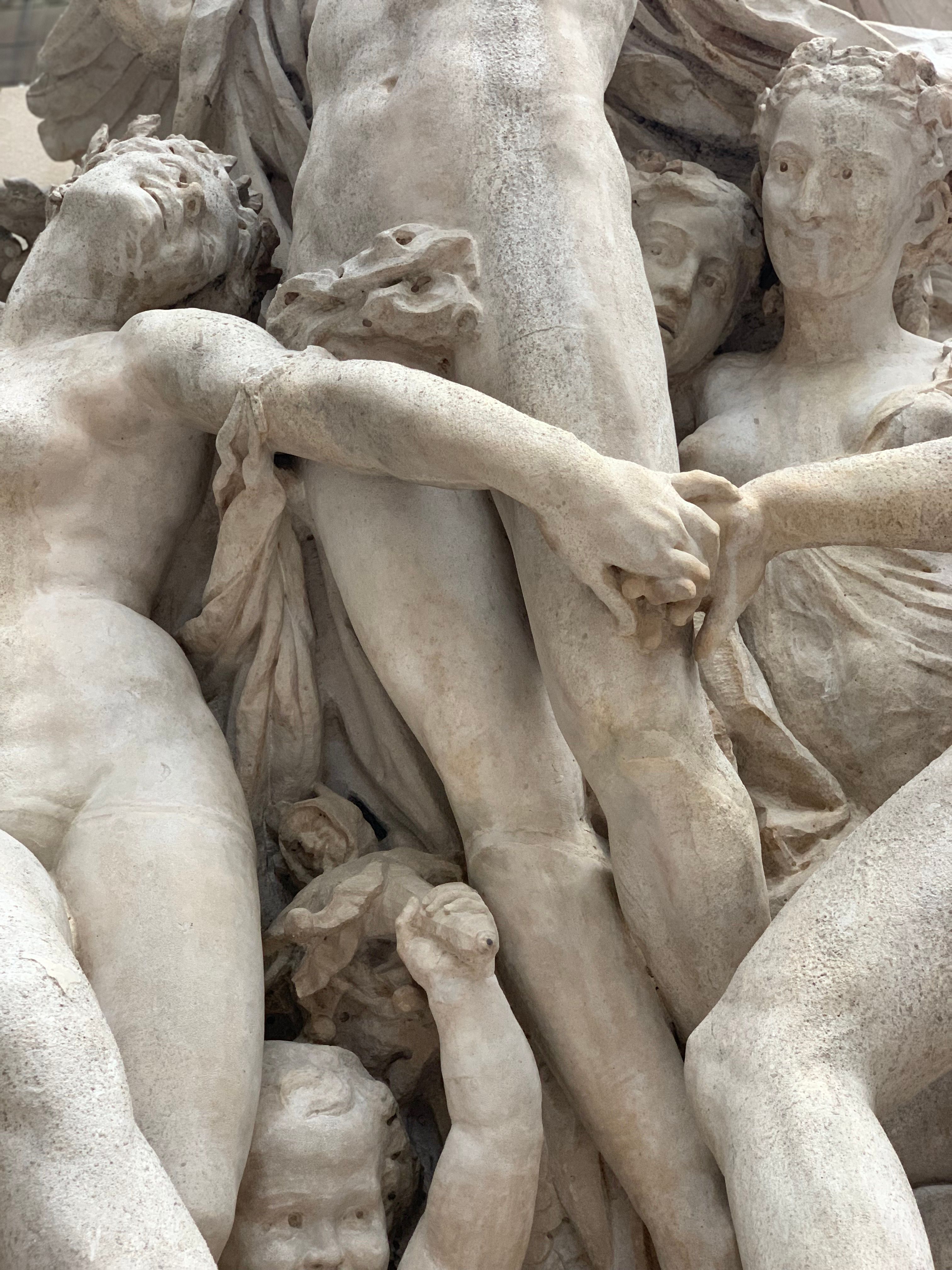 Close-up of a detailed marble sculpture depicting classical figures in an expressive pose.