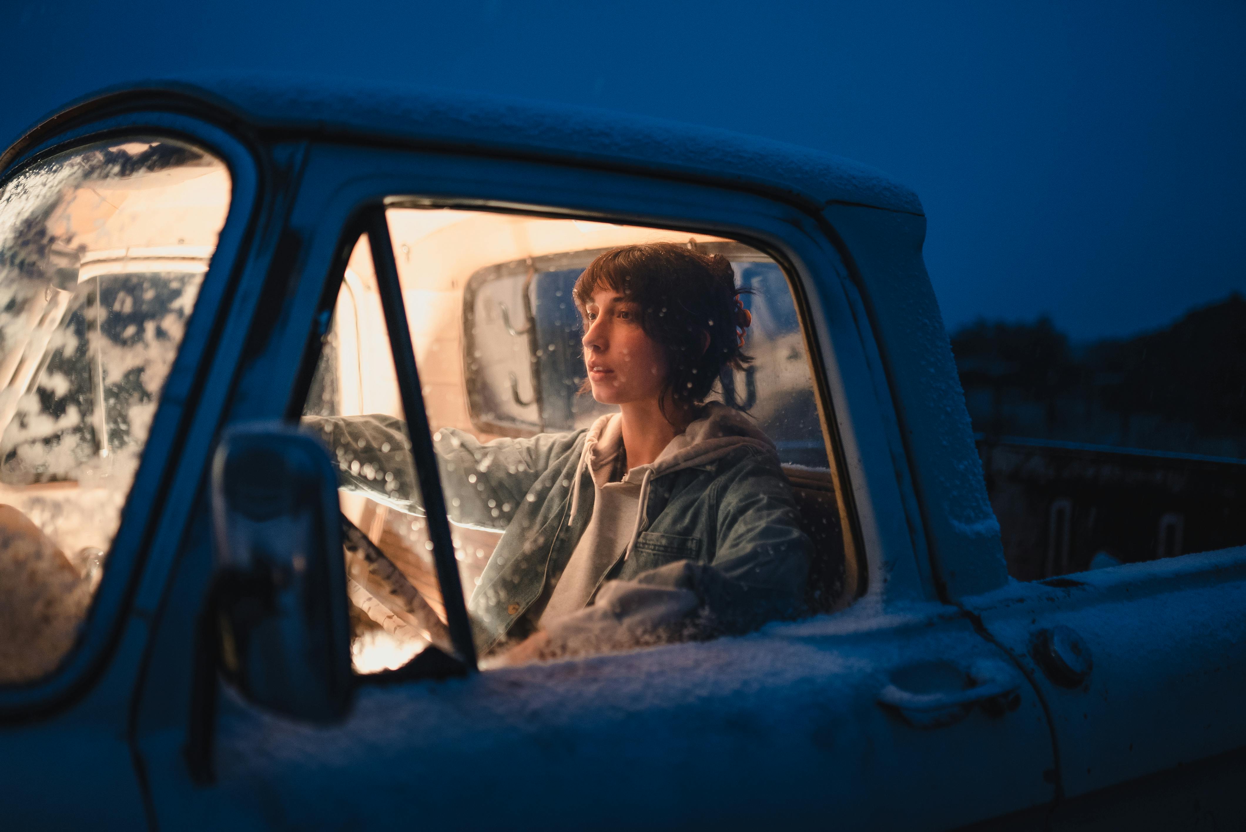 woman sitting in an old pick up truck in winter