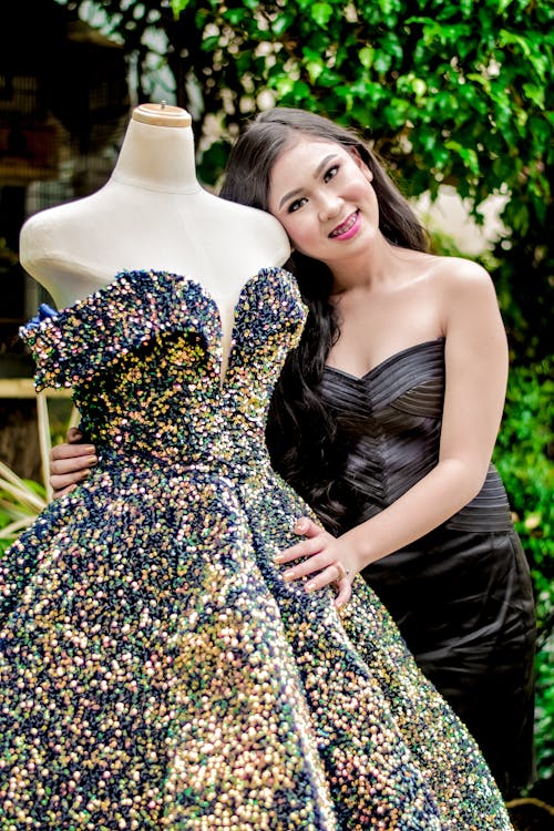 Woman in Mini Posing with Mannequin in Ball Gown