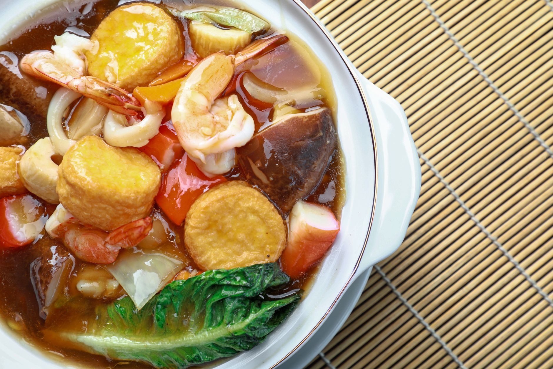 Vibrant seafood and vegetable hot pot with shrimp, tofu, and broth.