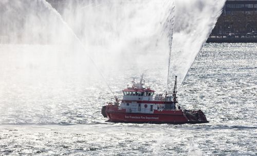 Free Fireboat sprays water while navigating San Francisco Bay, ensuring safety on the water. Stock Photo