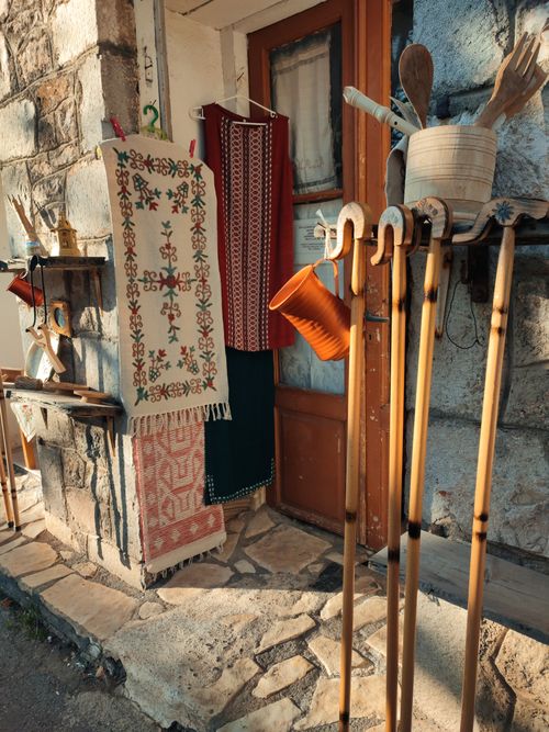 Free Charming display of traditional Greek textiles and crafts on a rustic village street. Stock Photo