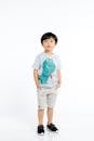 Studio Shot of a Little Boy Wearing a T-shirt with a Picture of a Dinosaur