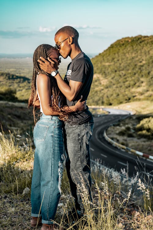 Young Couple Kissing on Top of a Hill 