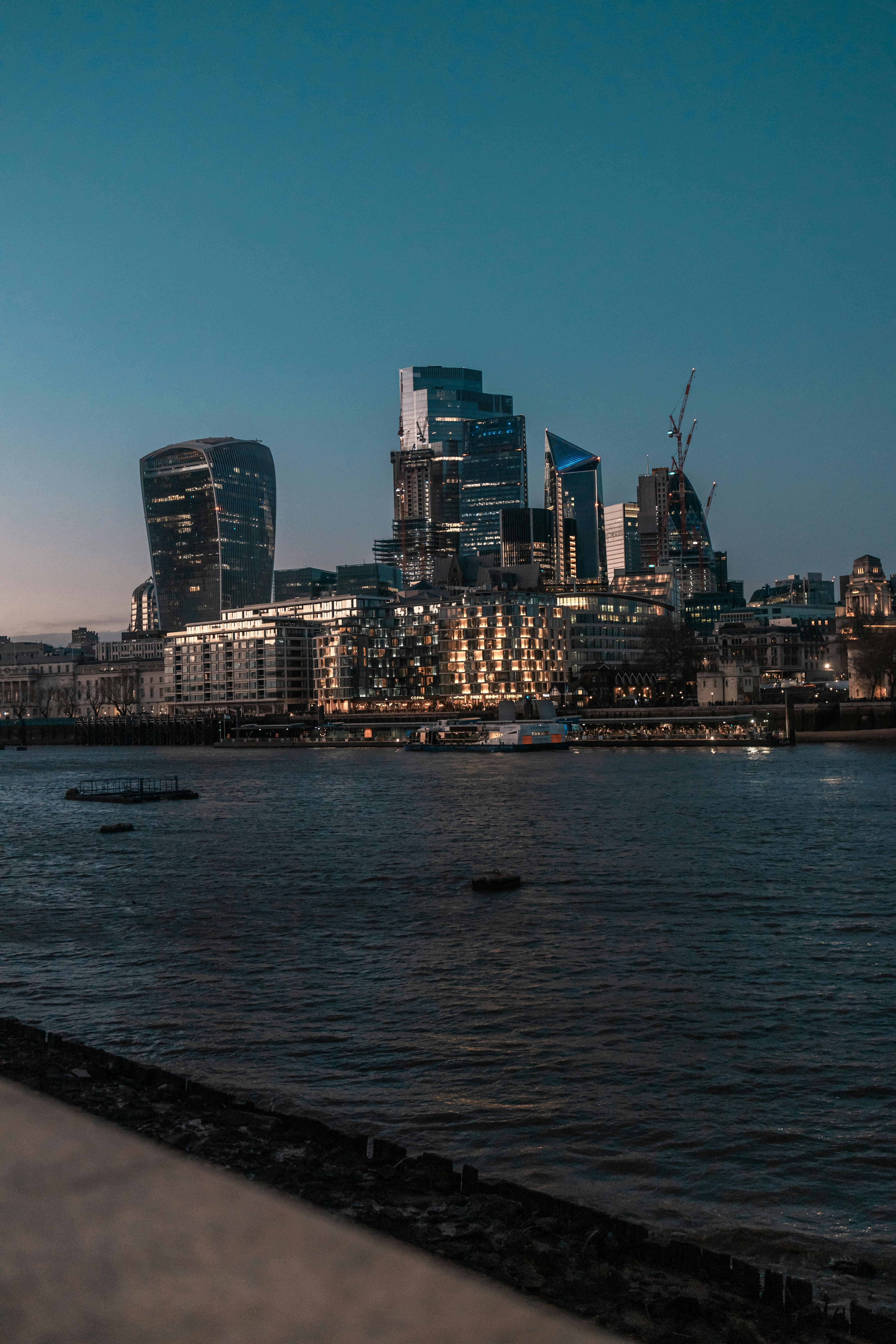 river thames with canary wharf skyscrapers in london uk