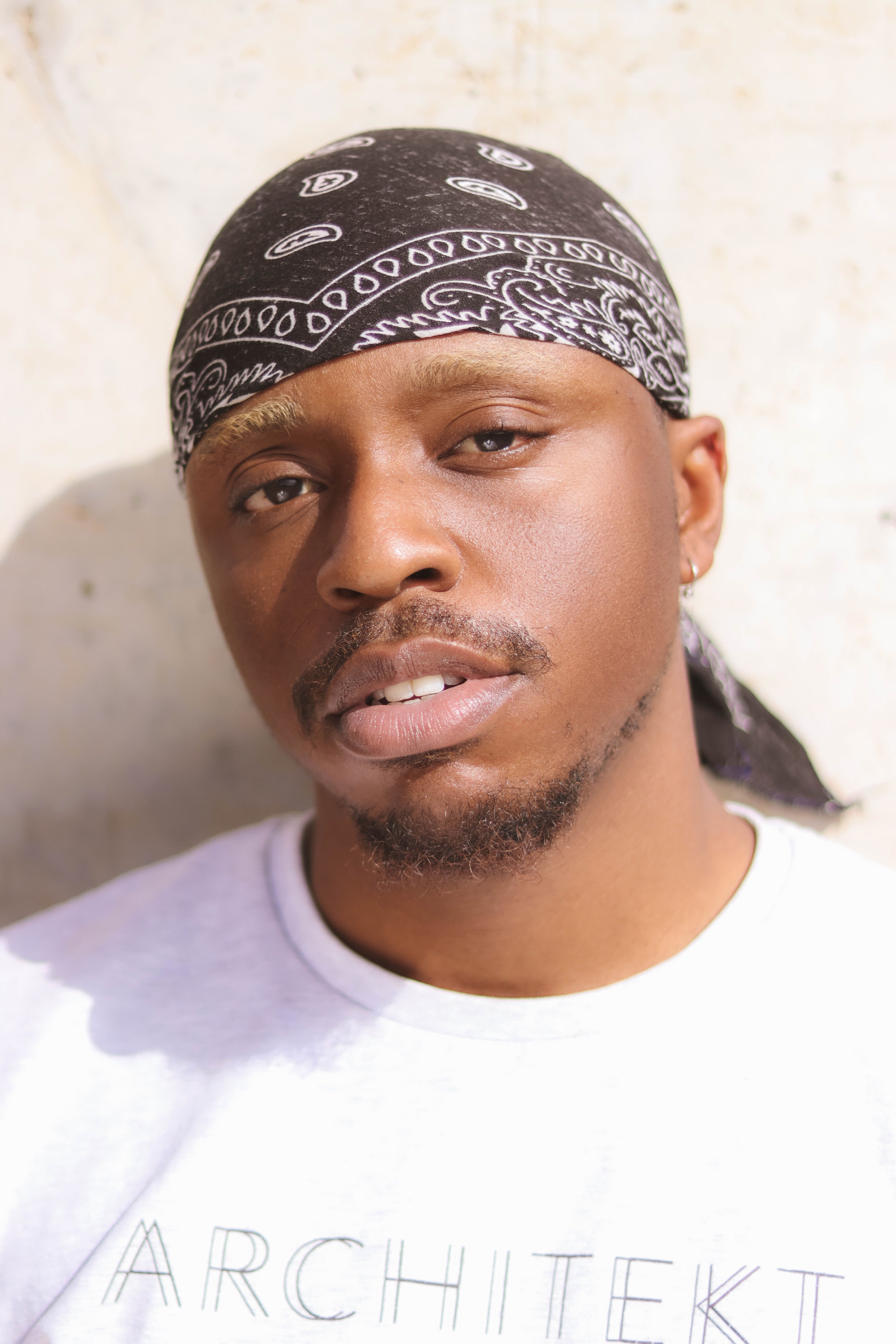 Portrait of a man wearing a bandana, shot outdoors with natural lighting.
