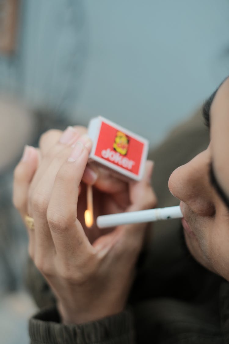 Man Lighting A Cigarette With A Match 