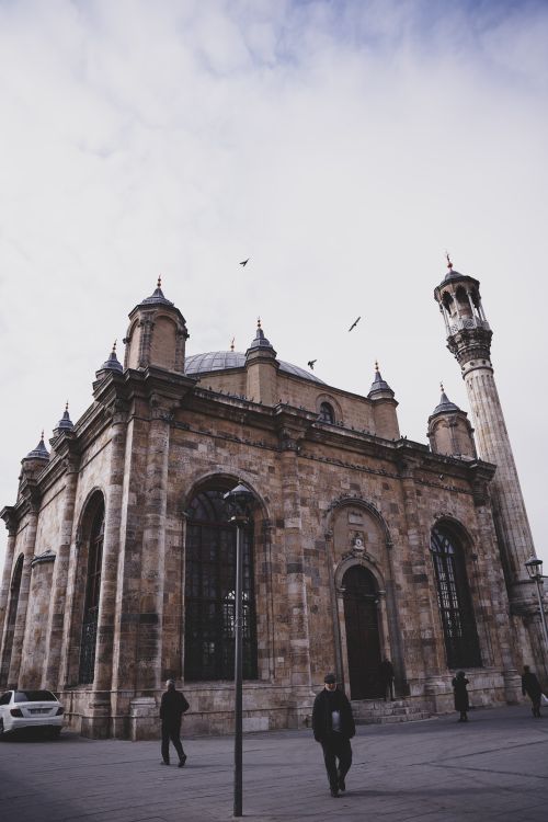 Free A stunning view of a historic mosque showcasing its intricate facade and towering minaret against a cloudy sky. Stock Photo