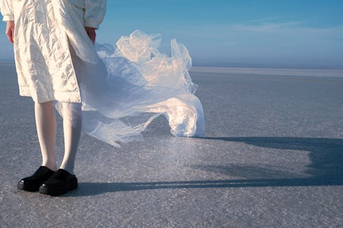 Legs of Person in White Clothes Standing on Ice