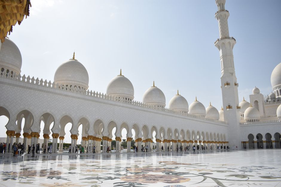 Stunning view of Sheikh Zayed Grand Mosque's courtyard, showcasing its beautiful architecture in bright daylight.
