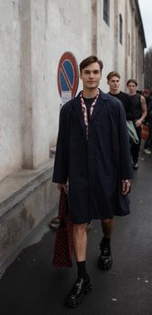 Group of fashionable men strolling on a street in Milano, showcasing casual yet trendy style.