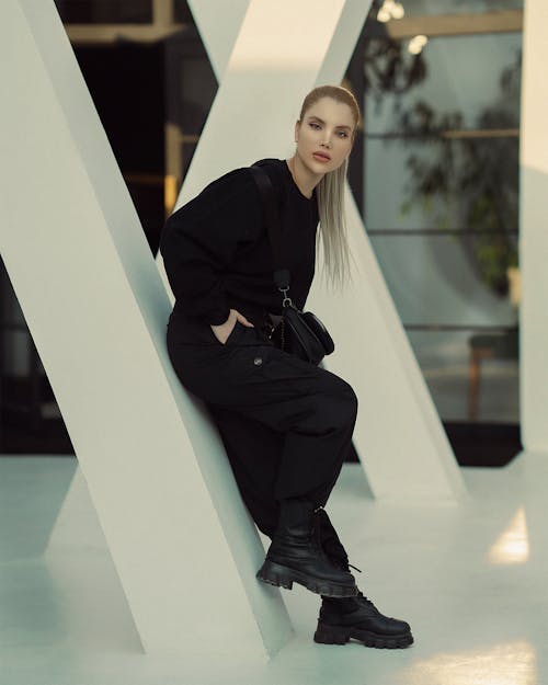 Young Woman in a Trendy, All Black Outfit Posing in a Modern Building 