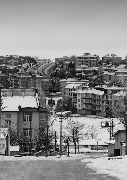 Grayscale Photo of a City Covered with Snow 