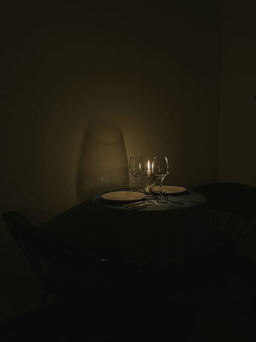 Empty Wine Glasses, Plates and a Candle Standing on a Table 
