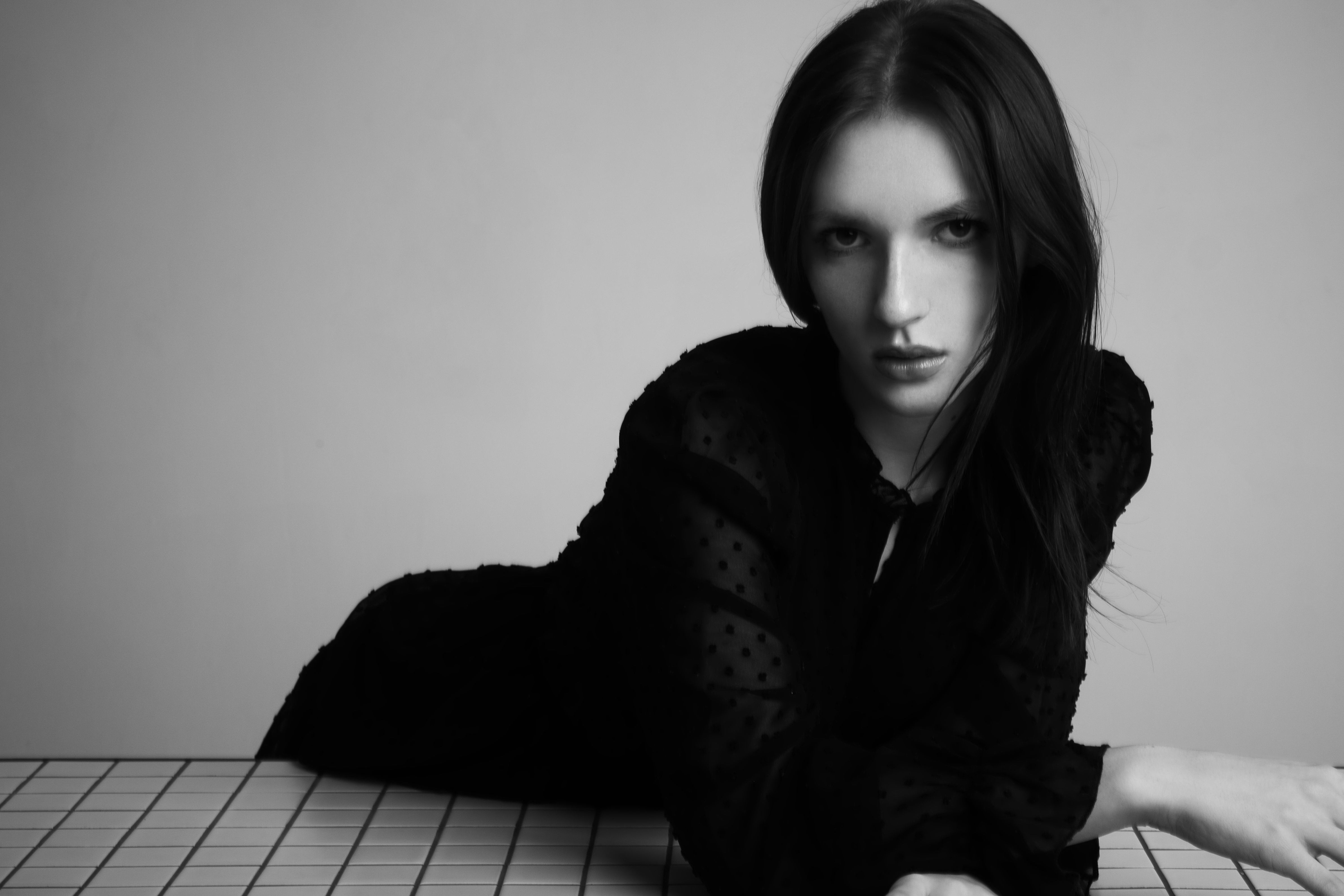 Elegant black and white portrait of a woman in a refined pose.