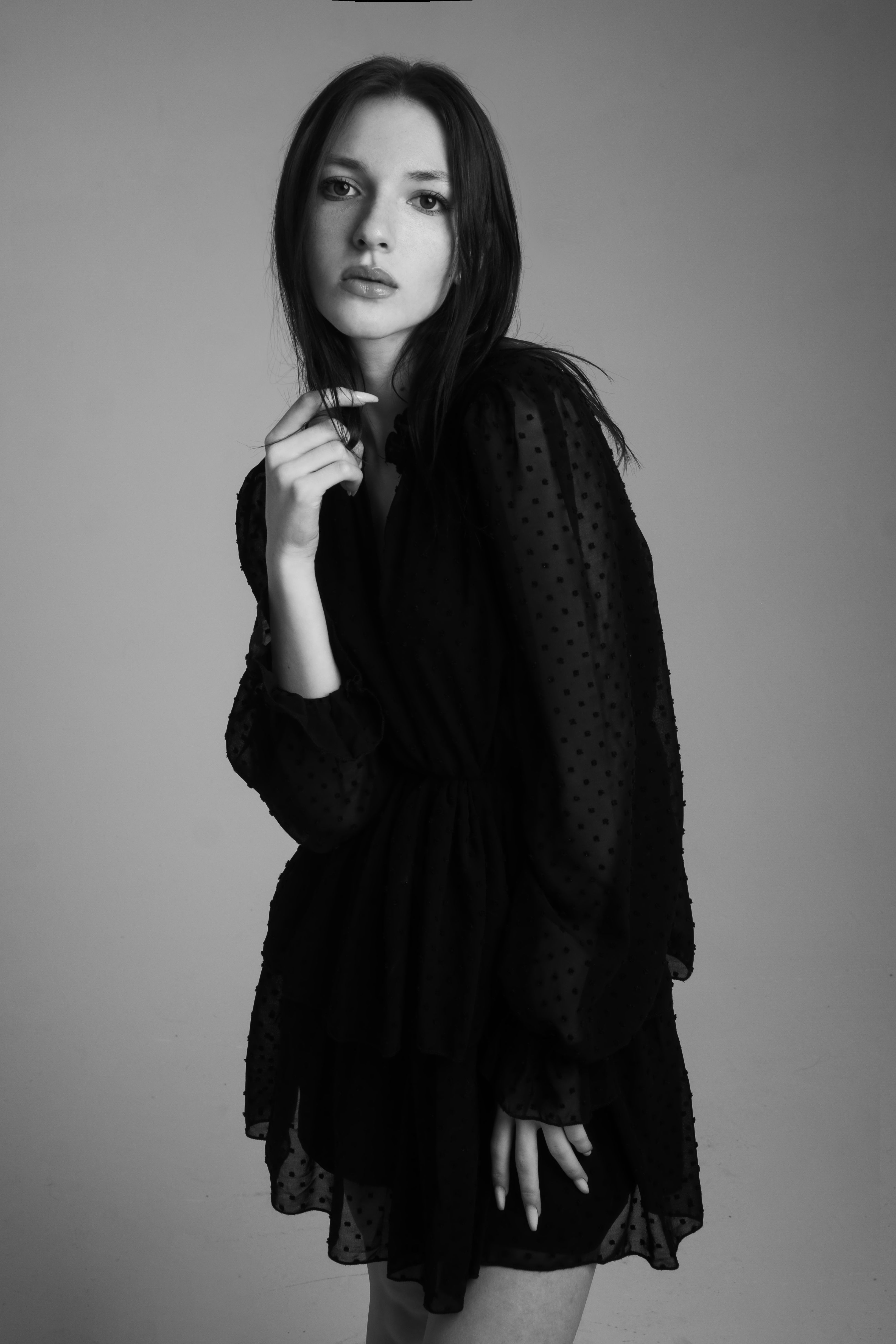 Sophisticated black and white portrait of a woman in a stylish black dress.