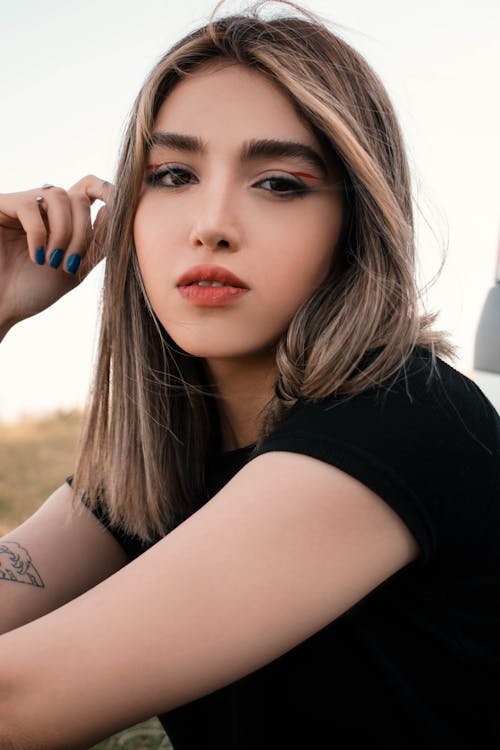 A woman with long hair and tattoos posing for a photo