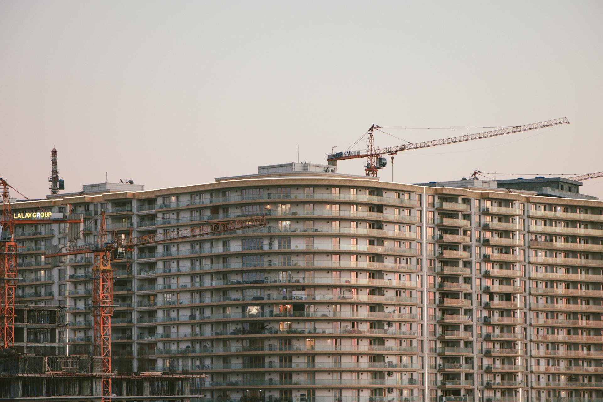 View of high-rise buildings and cranes at a construction site during daytime, capturing urban development.