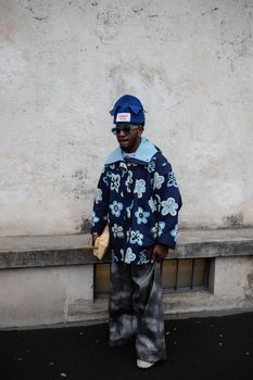 African American man in bold floral outfit on a Milan city street.