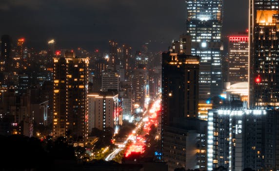 Stunning night view of a bustling city with illuminated skyscrapers and vibrant traffic lights.