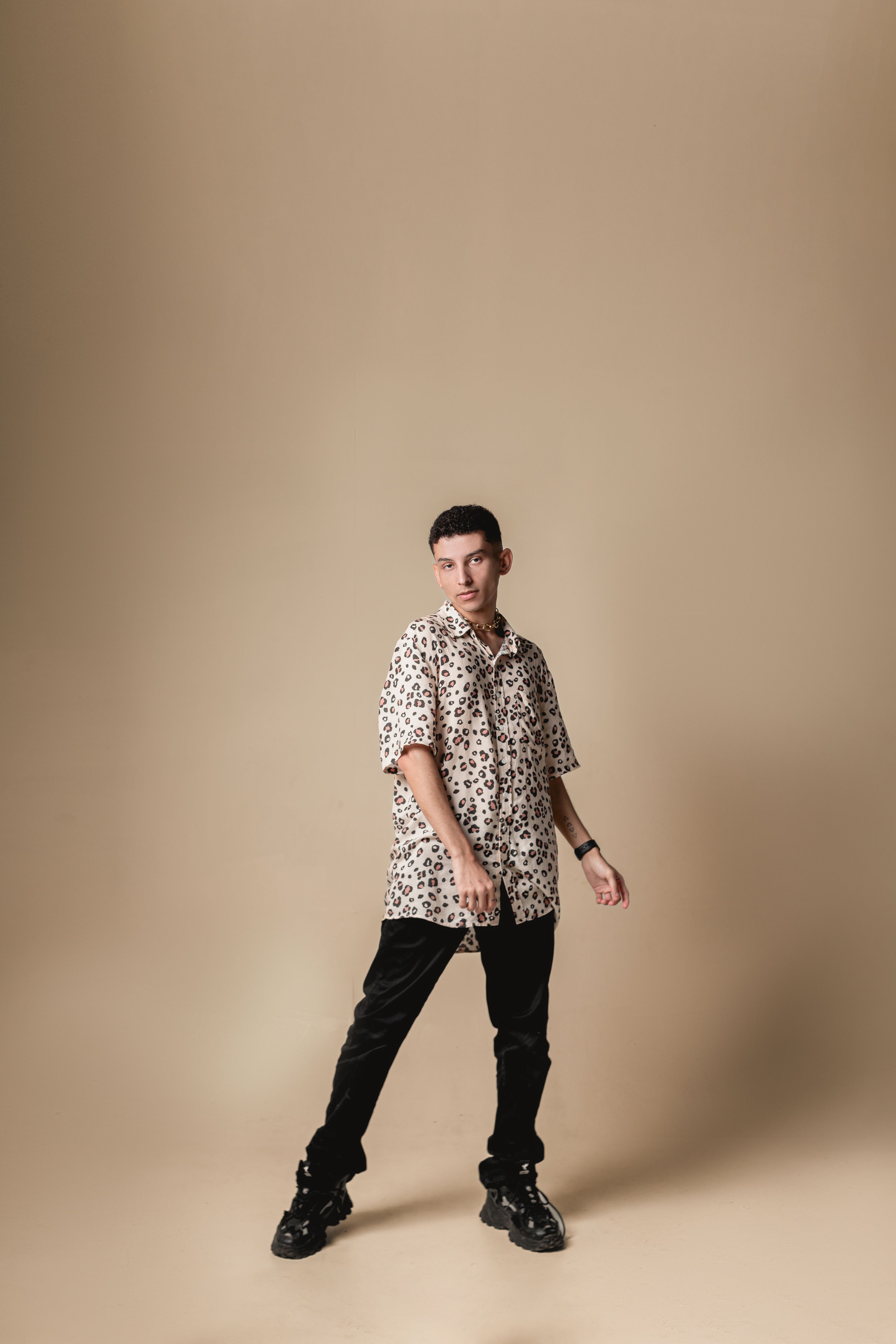 Jovem estiloso posando em um estúdio usando moda streetwear moderna. Perfeito para portfólios de moda.