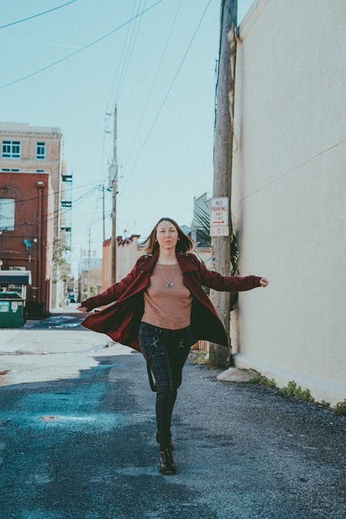 Woman Wearing Red Coat Walking on a Street 