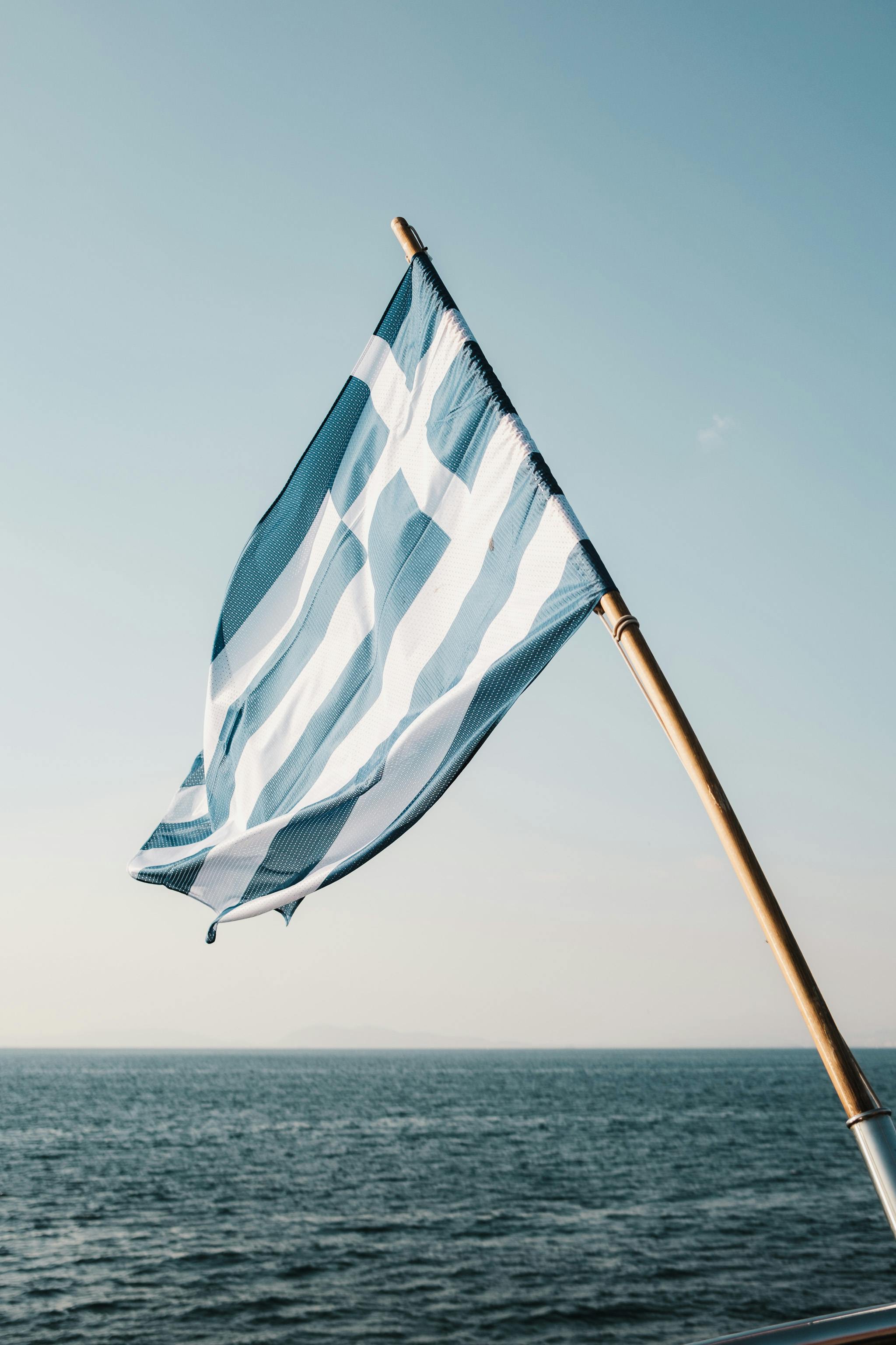 Die griechische Flagge weht unter blauem Himmel - ein lizenzfreies Stock  Foto von Photocase