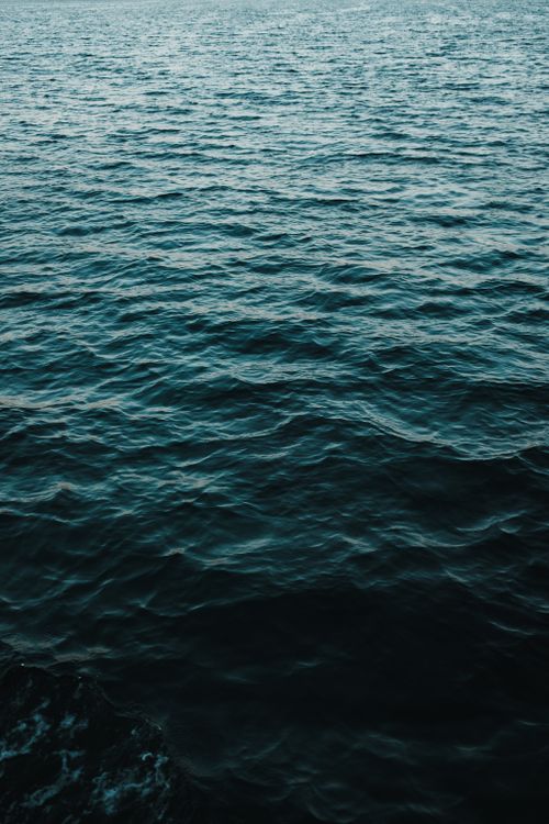 Free Calm ocean waves in summer, reflecting blue hues under the sunlight. Stock Photo