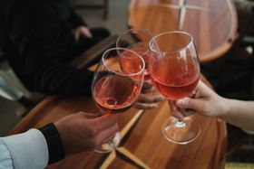 Three friends toasting with ros&eacute; over a wooden table — photo by Airam Dato-on on Pexels