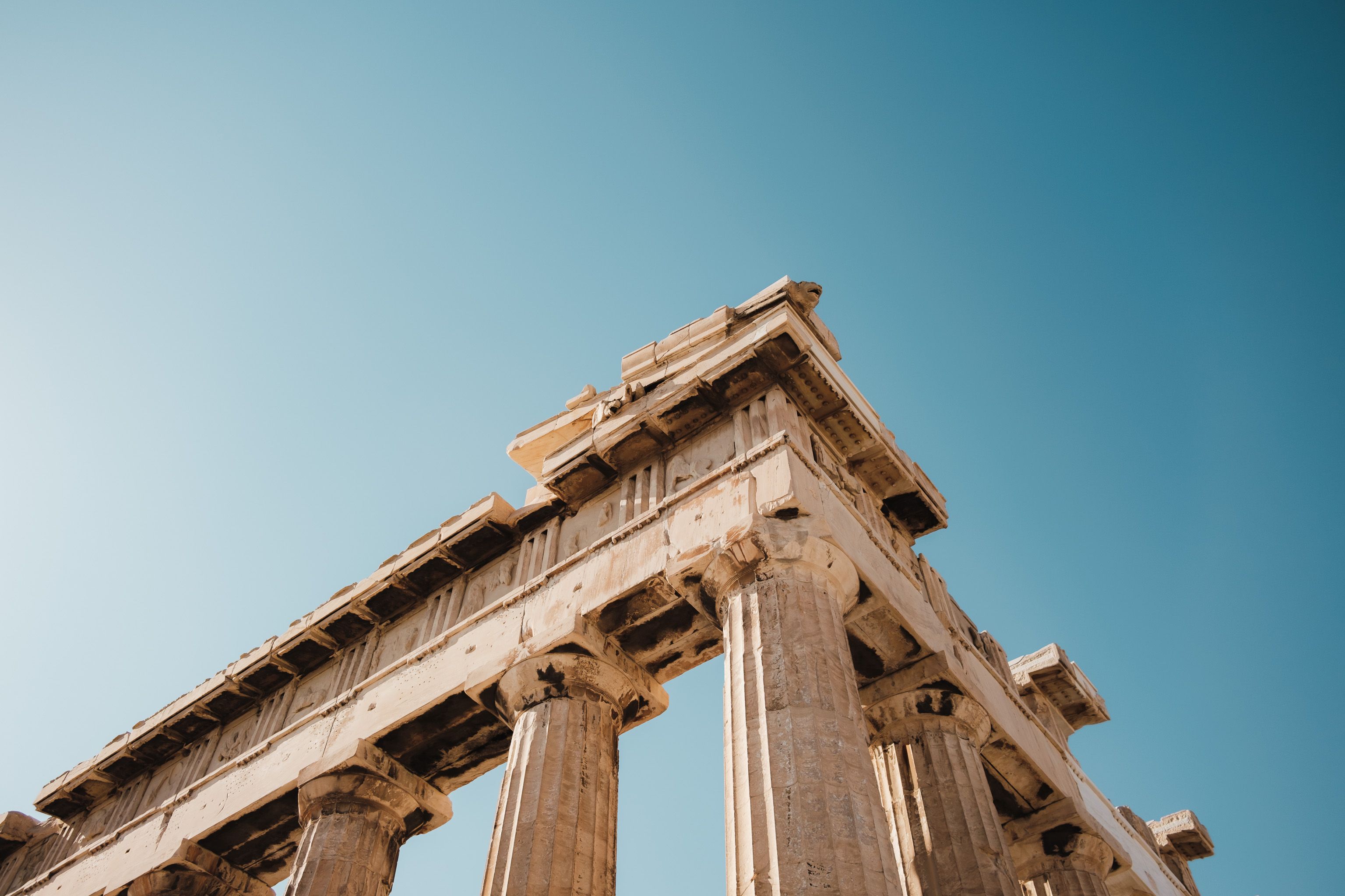 Ancient ruins of the Parthenon in Athens, Greece, showcasing iconic architectural columns against a clear blue sky.