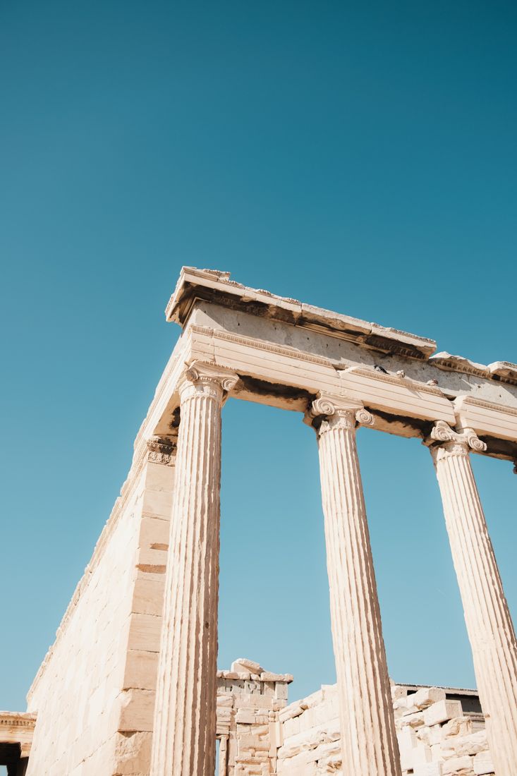 Weathered marble columns of an ancient Greek temple against the sky