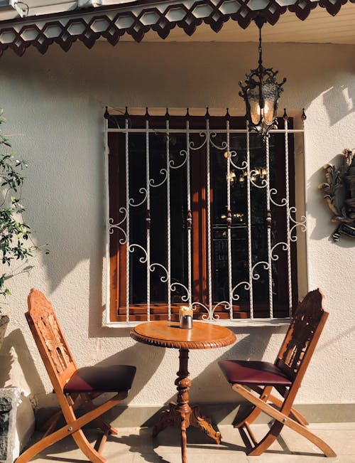 Wooden Table and Chairs near the Wooden Frame Glass Window 