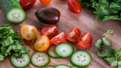 Tomatoes, lettuce and cucumber on rustic wooden table