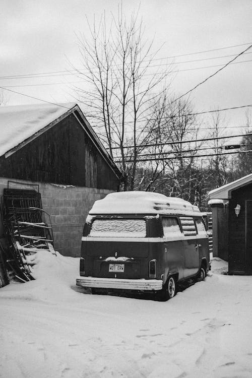 Minivan in Snow near House in Winter Landscape