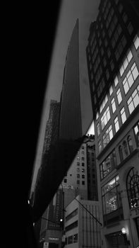 Black and white cityscape of New York City skyscrapers, captured with a reflective perspective.