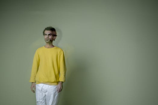 A creative portrait featuring a man in a yellow sweatshirt with a blurred motion effect.