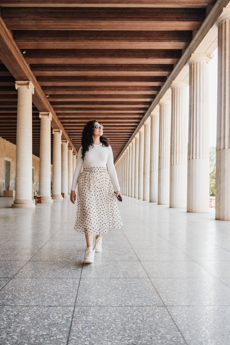 Woman Walking Among Columns