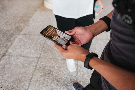 A person holding a smartphone displaying a photo, highlighting casual urban smartphone use.