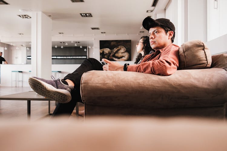 Man And Woman Sitting On Couch