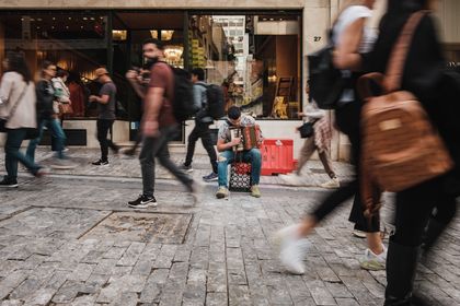 Accordion player busking as pedestrians pass on a city street, photo by Airam Dato-on on Pexels