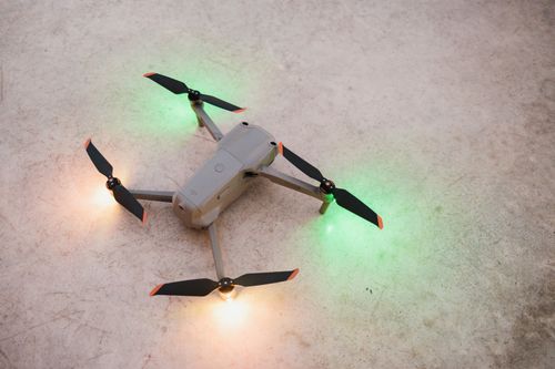 Free Close-up of a drone on the ground with glowing lights, showcasing modern technology. Stock Photo