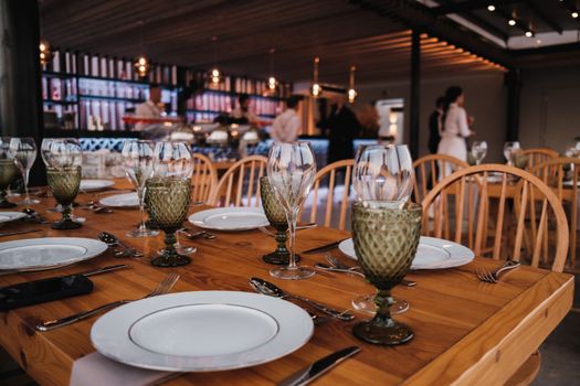 A beautifully set restaurant table with glassware, plates, and cutlery in a cozy atmosphere.
