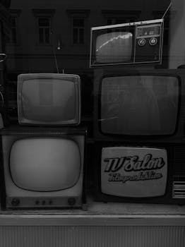 Monochrome photo of vintage televisions on display, capturing a sense of nostalgia.