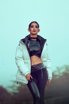 Fashionable woman posing outdoors in winter attire, showcasing modern style.